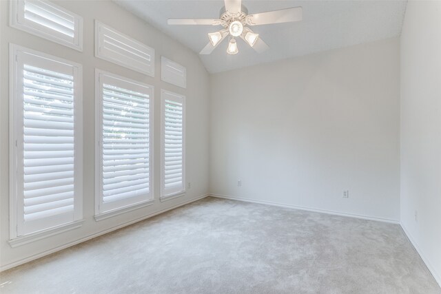 unfurnished room featuring ceiling fan, vaulted ceiling, and light colored carpet