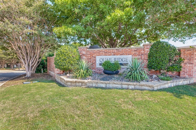 community / neighborhood sign featuring a lawn