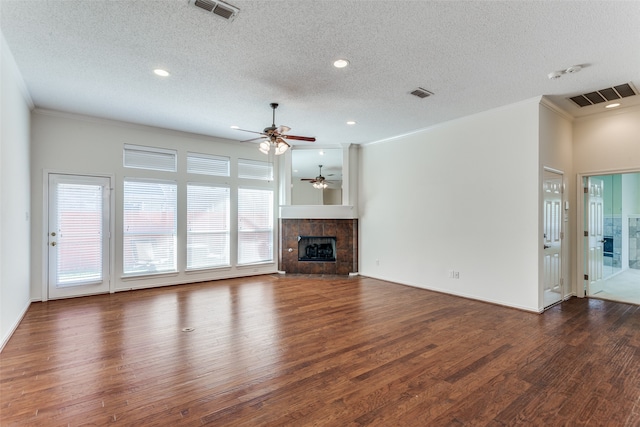 unfurnished living room featuring a textured ceiling, dark wood-type flooring, a fireplace, and ceiling fan