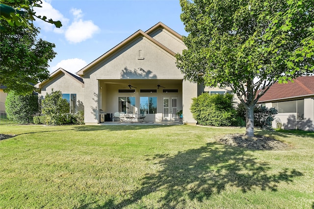 back of property featuring a lawn, ceiling fan, and a patio