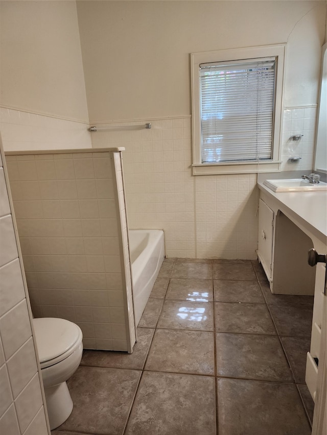 bathroom with tile walls, a washtub, tile patterned floors, vanity, and toilet