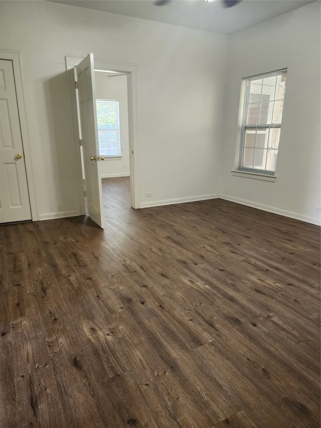 empty room featuring a healthy amount of sunlight and dark hardwood / wood-style flooring