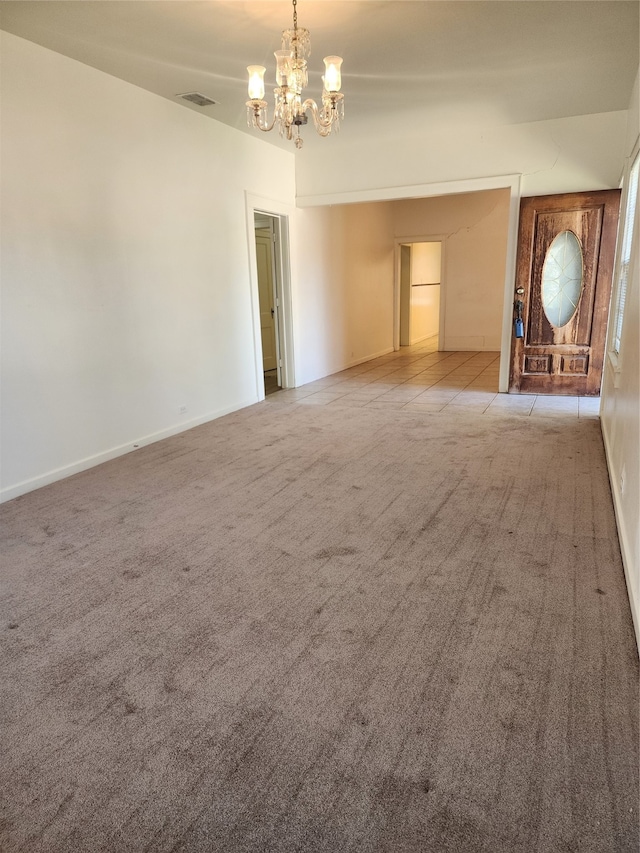 unfurnished living room featuring light carpet and an inviting chandelier