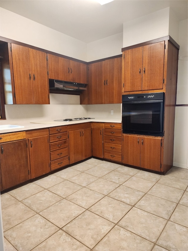 kitchen with light tile patterned flooring, sink, oven, exhaust hood, and white gas stovetop