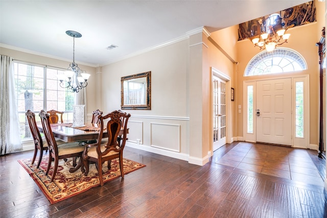 dining space featuring a notable chandelier, ornamental molding, dark wood-type flooring, and a wealth of natural light