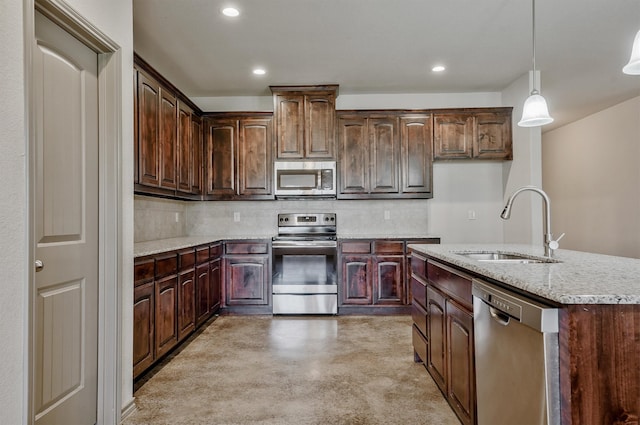 kitchen featuring dark brown cabinetry, pendant lighting, sink, backsplash, and appliances with stainless steel finishes