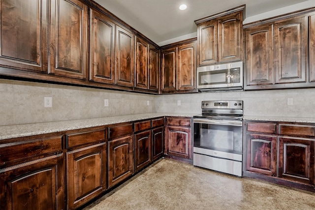 kitchen with dark brown cabinetry, light stone countertops, stainless steel appliances, and backsplash