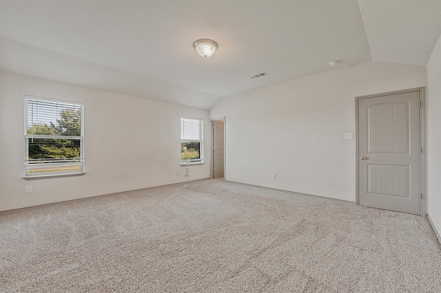 unfurnished room featuring carpet floors and lofted ceiling