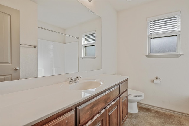 bathroom with walk in shower, vanity, and toilet