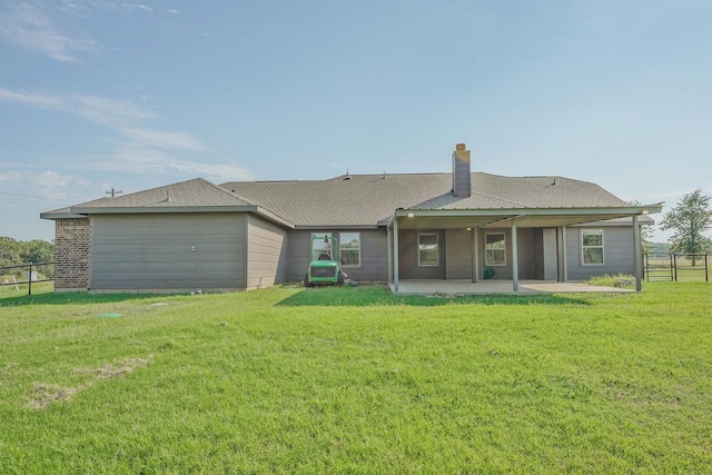 back of house with a lawn and a patio area