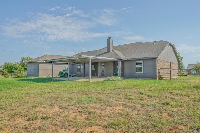 rear view of house featuring a yard and a patio