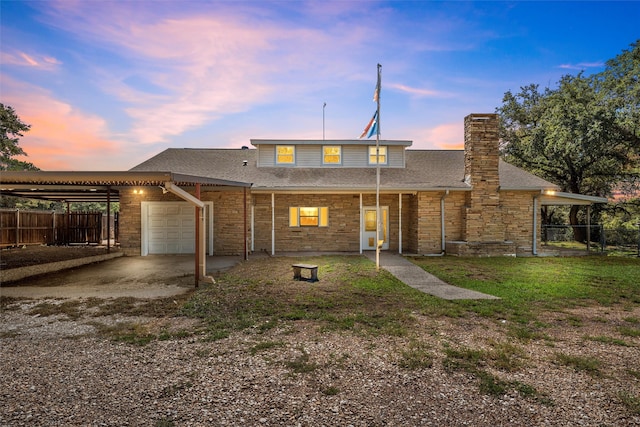 back house at dusk with a garage, a lawn, and a carport