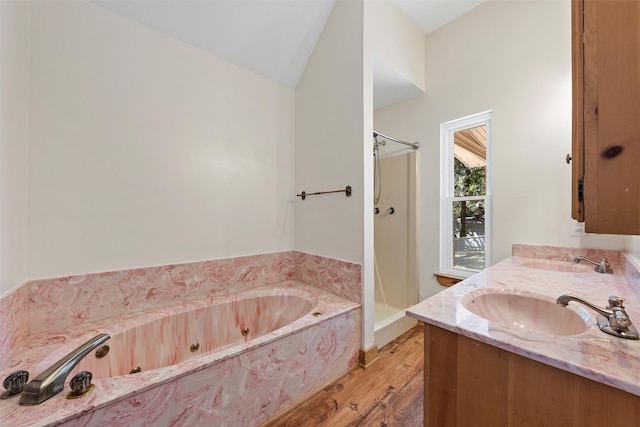 bathroom featuring vanity, vaulted ceiling, hardwood / wood-style floors, and separate shower and tub