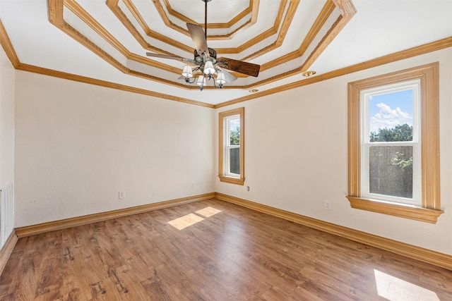 empty room featuring plenty of natural light, hardwood / wood-style floors, and crown molding