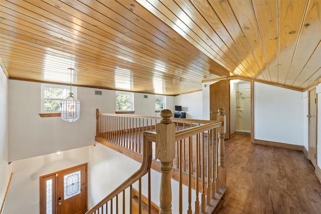 hallway with plenty of natural light, lofted ceiling, hardwood / wood-style flooring, and wooden ceiling