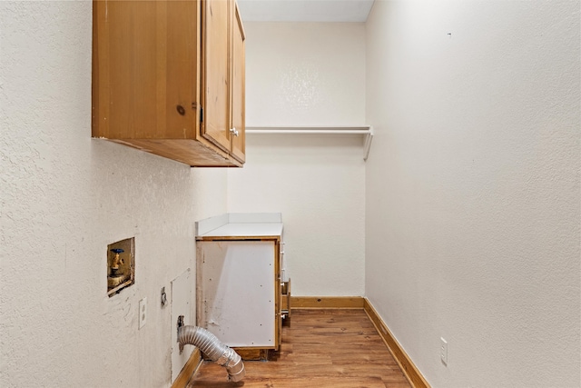 laundry room with light wood-type flooring, hookup for a washing machine, and cabinets