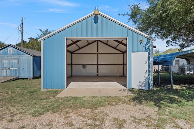 garage with wooden walls, a lawn, and a carport