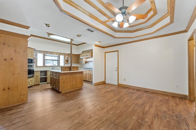 kitchen featuring hardwood / wood-style floors, ornamental molding, and a kitchen island