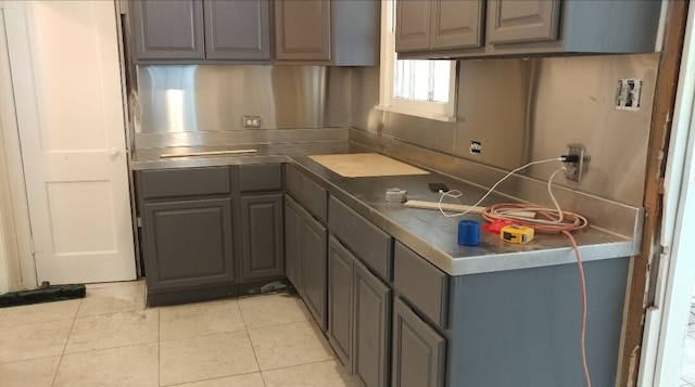 kitchen with gray cabinets and light tile patterned flooring