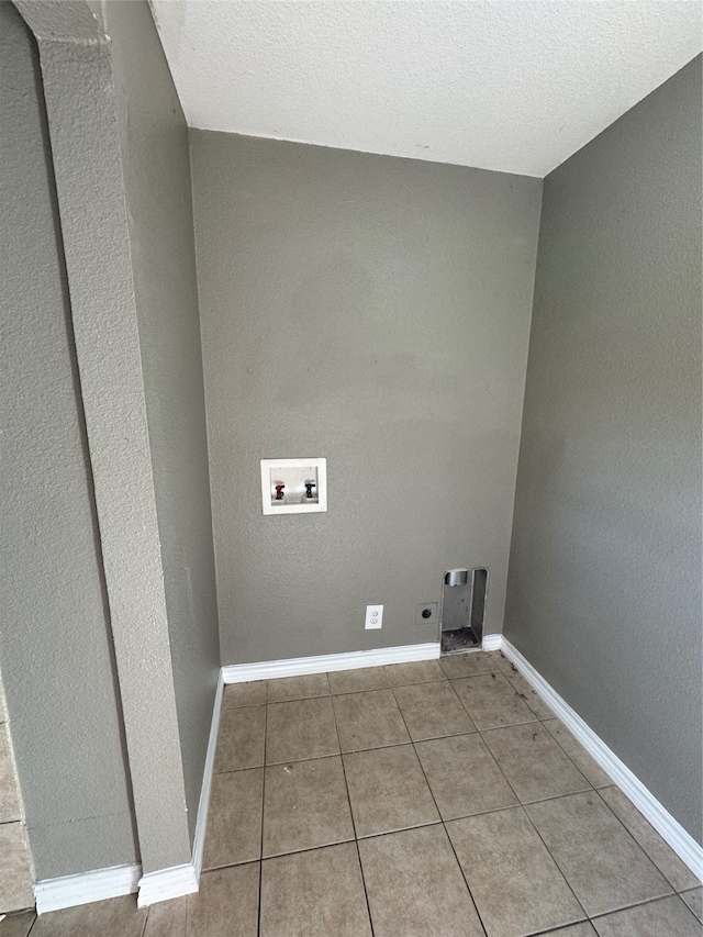 laundry room with a textured ceiling, hookup for an electric dryer, washer hookup, and tile patterned floors