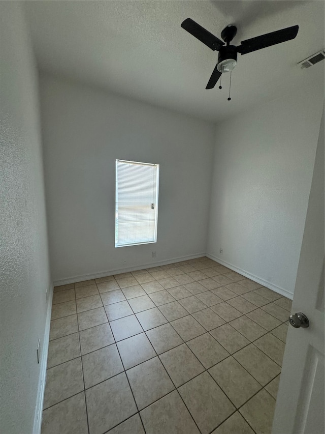 tiled spare room featuring ceiling fan