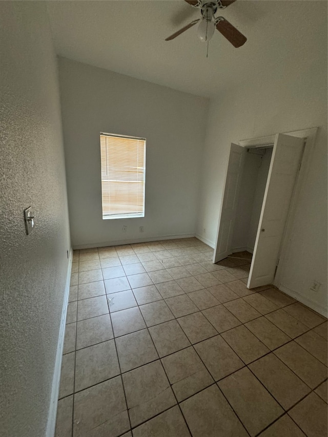 unfurnished bedroom featuring a closet, ceiling fan, and light tile patterned floors