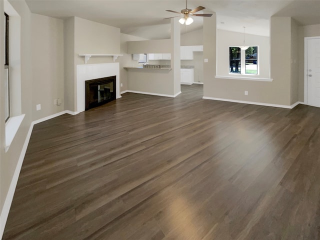 unfurnished living room featuring lofted ceiling, ceiling fan, and dark wood-type flooring