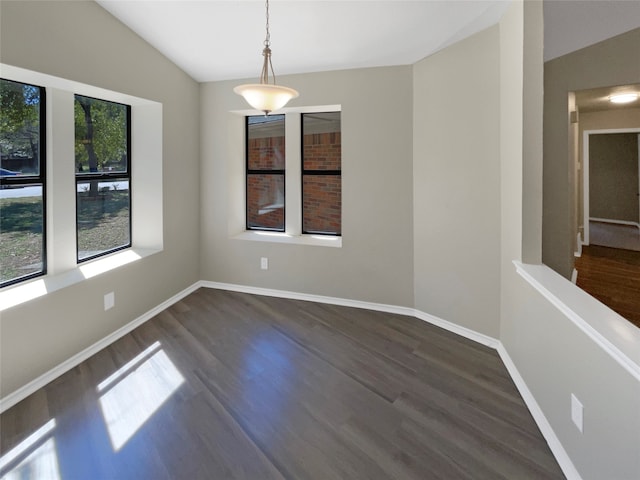 spare room featuring lofted ceiling and dark hardwood / wood-style flooring