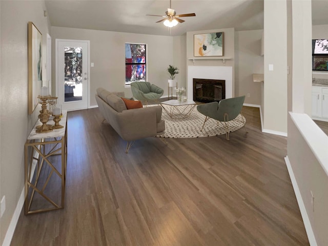 living room with ceiling fan and dark hardwood / wood-style flooring