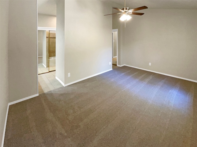 carpeted spare room featuring ceiling fan and vaulted ceiling