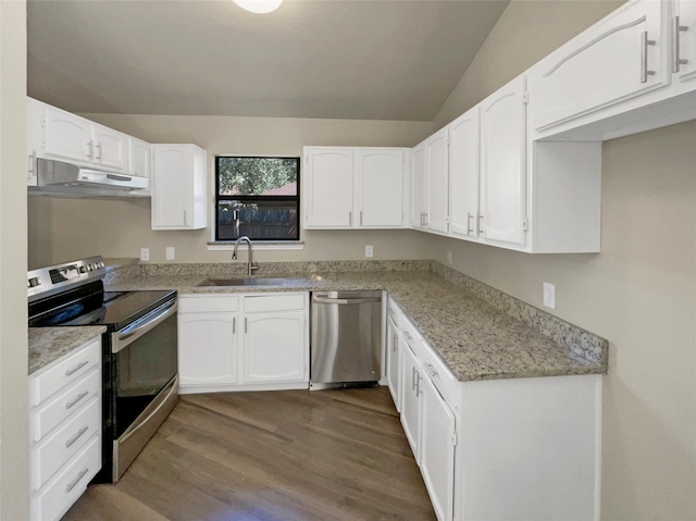 kitchen with white cabinets, sink, wood-type flooring, appliances with stainless steel finishes, and vaulted ceiling