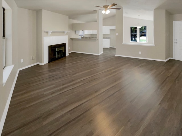 409 Misty Oaks St, Azle, TX 76020 - unfurnished living room featuring vaulted ceiling, ceiling fan, dark wood-style floors, baseboards, and a glass covered fireplace