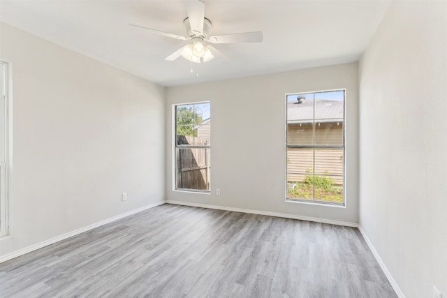 unfurnished room featuring a wealth of natural light, ceiling fan, and light hardwood / wood-style flooring