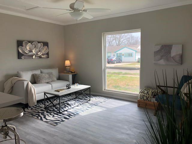 living room with crown molding, ceiling fan, wood-type flooring, and a wealth of natural light