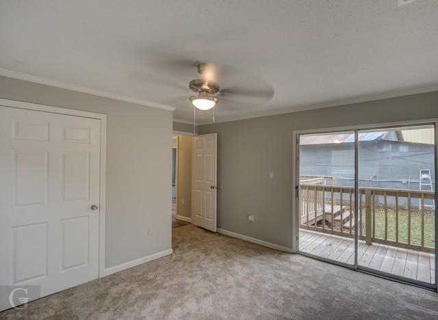 carpeted spare room with ceiling fan and crown molding