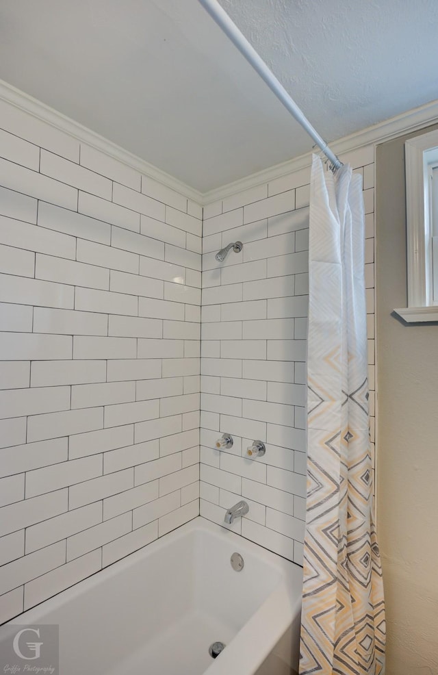 bathroom with crown molding and shower / tub combo