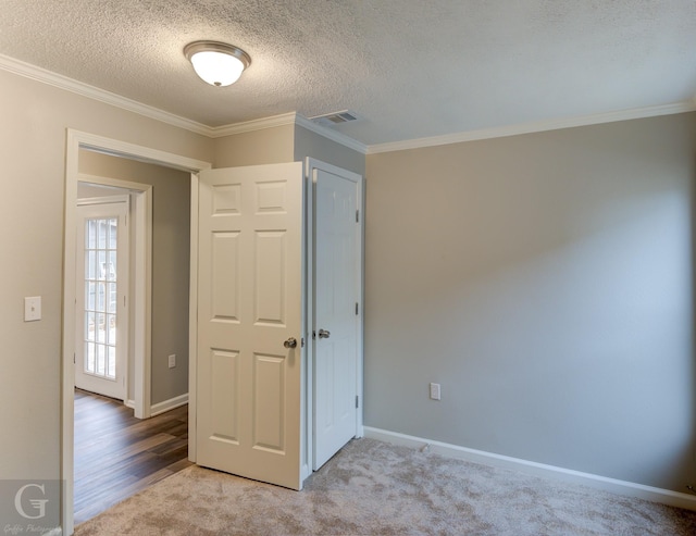 carpeted spare room featuring a textured ceiling and crown molding