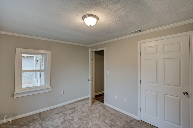 unfurnished bedroom featuring a textured ceiling, a closet, crown molding, and light colored carpet