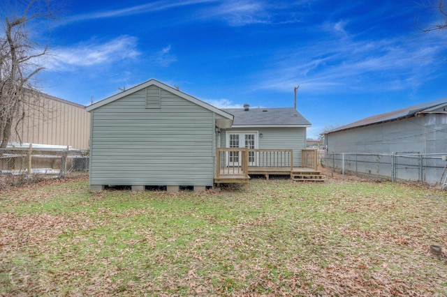 rear view of property with a wooden deck and a lawn