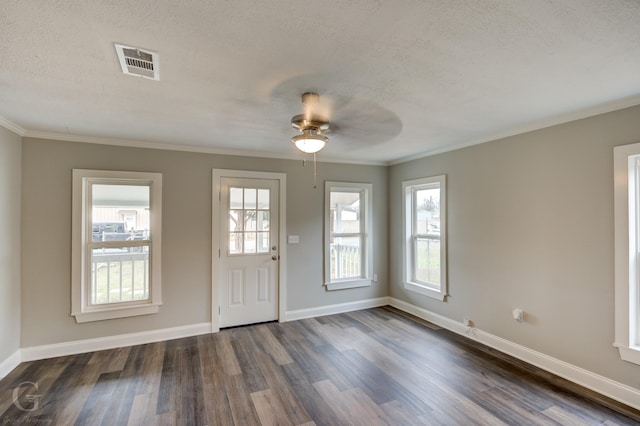 entrance foyer with a textured ceiling, dark wood-type flooring, a healthy amount of sunlight, and crown molding