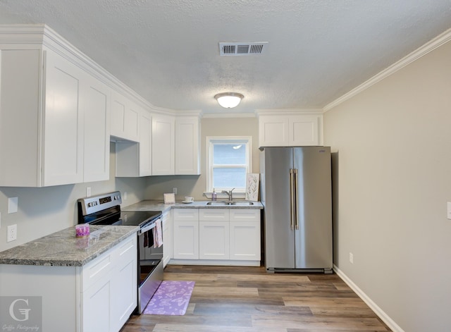 kitchen with stainless steel appliances, crown molding, white cabinetry, and sink