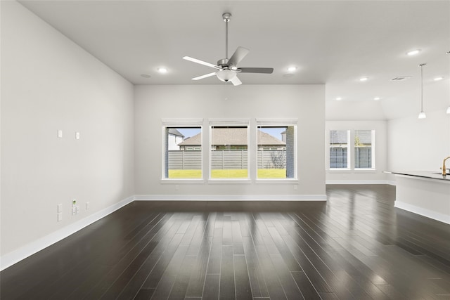 unfurnished living room with ceiling fan, lofted ceiling, plenty of natural light, and dark wood-type flooring