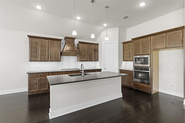 kitchen featuring custom range hood, decorative light fixtures, appliances with stainless steel finishes, and dark hardwood / wood-style flooring