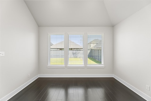 empty room with dark wood-type flooring and vaulted ceiling