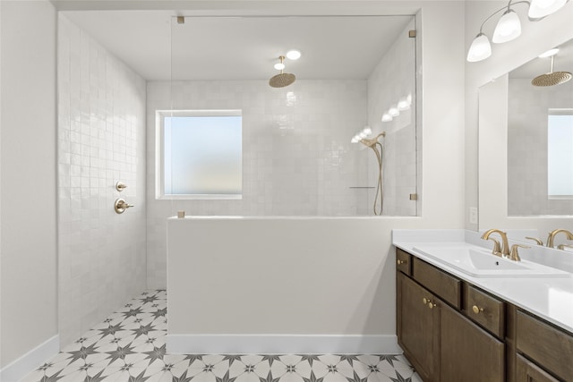 bathroom with vanity, a tile shower, and a wealth of natural light