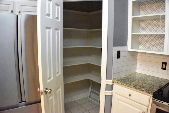 spare room with crown molding, light tile patterned floors, and ceiling fan