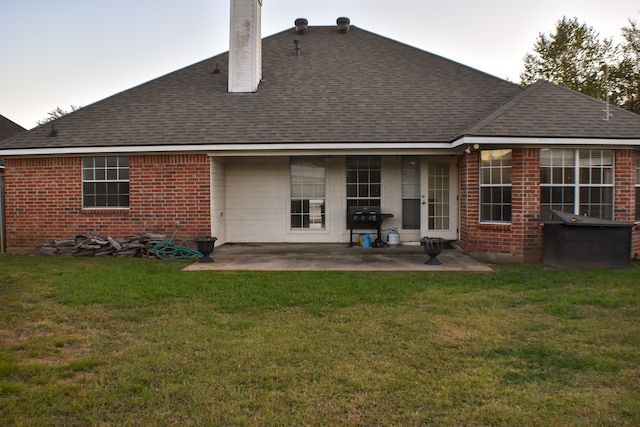 back of house featuring a patio area and a lawn