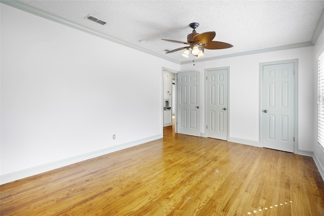 unfurnished bedroom featuring a textured ceiling, multiple closets, light hardwood / wood-style flooring, ornamental molding, and ceiling fan