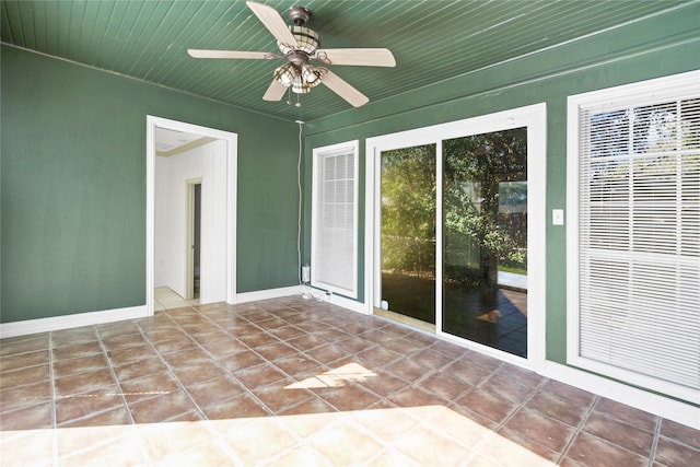 unfurnished sunroom with ceiling fan