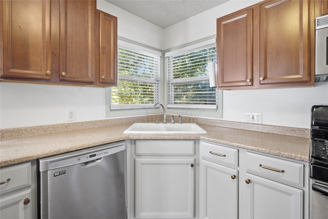 kitchen with sink, white cabinetry, a textured ceiling, and stainless steel dishwasher